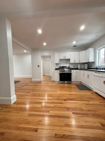 a large kitchen with kitchen island a sink stainless steel appliances and cabinets