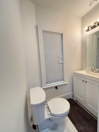 a bathroom with a toilet a sink and mirror