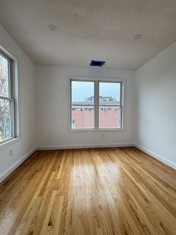 554 Main Street, Unit 2 Wakefield, MA 01880 - Photo 6 of 16 an empty room with wooden floor and windows