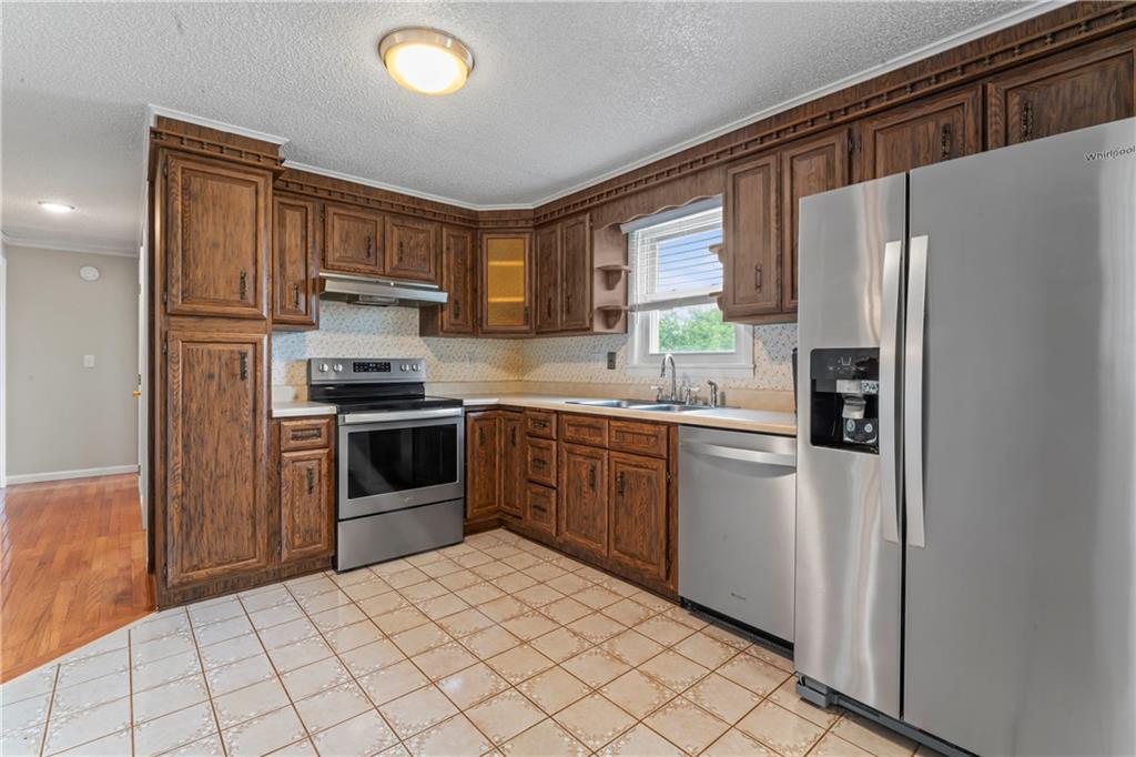 1032 Grove Street Monaca, PA 15061 - Photo 7 of 25 a kitchen with stainless steel appliances a refrigerator sink and microwave