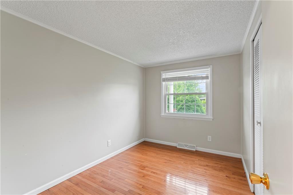1032 Grove Street Monaca, PA 15061 - Photo 10 of 25 an empty room with wooden floor and windows