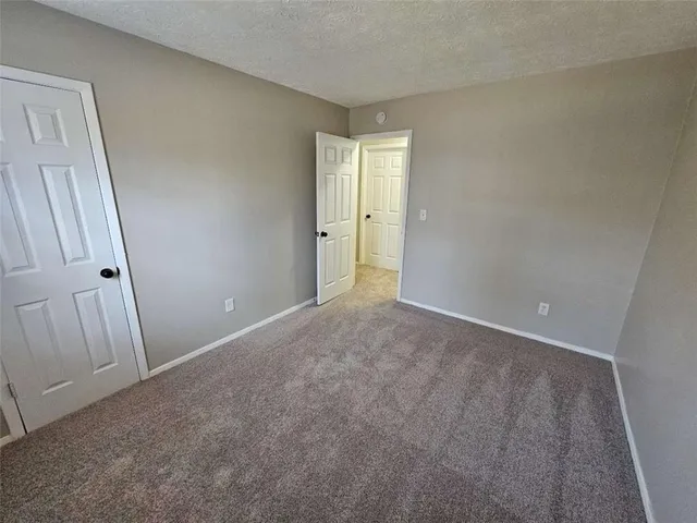 an empty room with wooden floor and a mirror