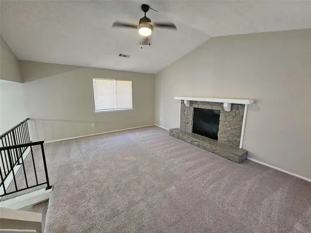 an empty room with windows and fireplace