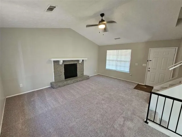 a view of an empty room with a fireplace and a window