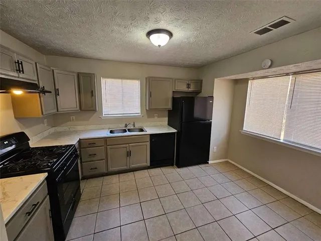 a kitchen with a stove a refrigerator and a sink