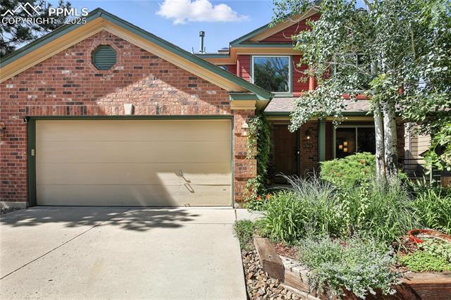 2130 Wickes Road Colorado Springs, CO 80919 - Photo 2 of 49 View of front of property featuring driveway, brick siding, and a garage