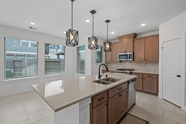 a kitchen with a sink a counter top space a stove and a refrigerator