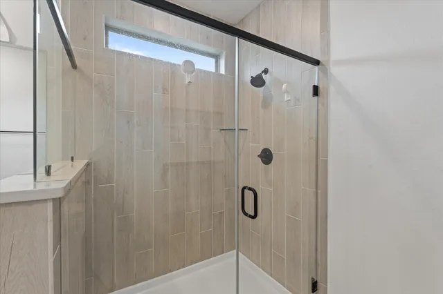 a spacious bathroom with a double vanity sink a mirror and shower