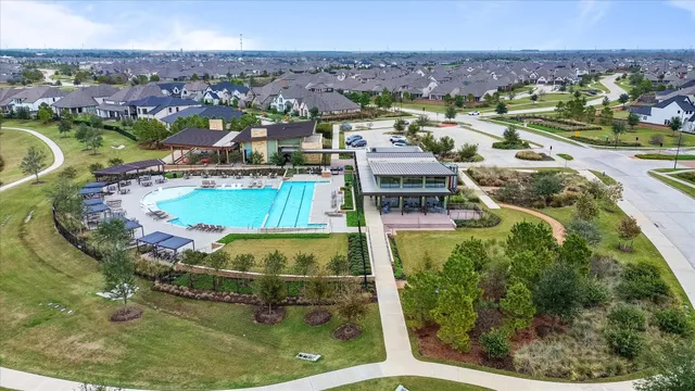 an aerial view of residential houses with outdoor space and swimming pool