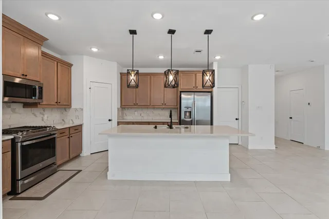 a kitchen with stainless steel appliances granite countertop a sink a refrigerator and a sink