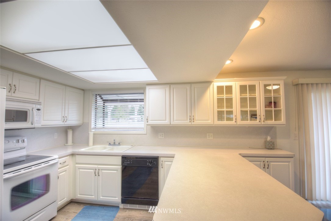 8446 178th Avenue Southwest Rochester, WA 98579 - Photo 12 of 34 a kitchen with stainless steel appliances granite countertop a sink and dishwasher a stove top oven with wooden floor