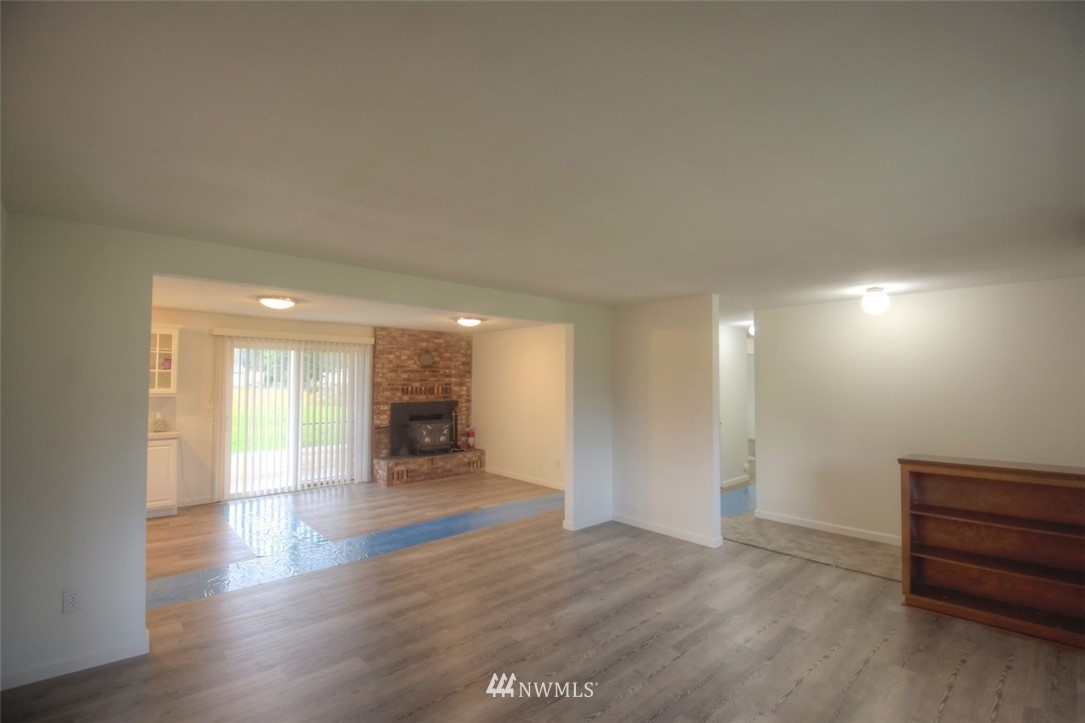 8446 178th Avenue Southwest Rochester, WA 98579 - Photo 4 of 34 a view of an empty room and a kitchen with wooden floor