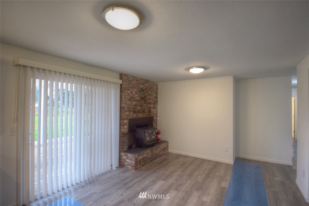 8446 178th Avenue Southwest Rochester, WA 98579 - Photo 5 of 34 an empty room with wooden floor and windows