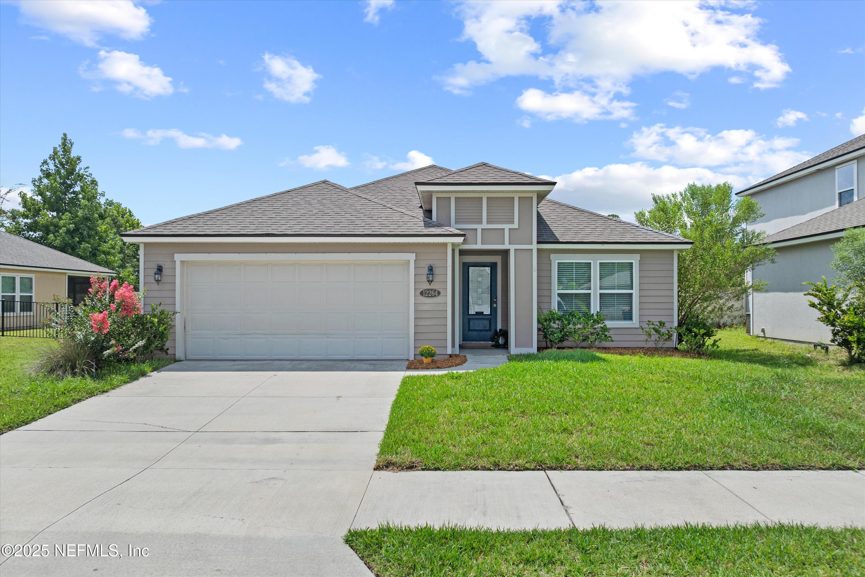 a front view of a house with a yard and garage