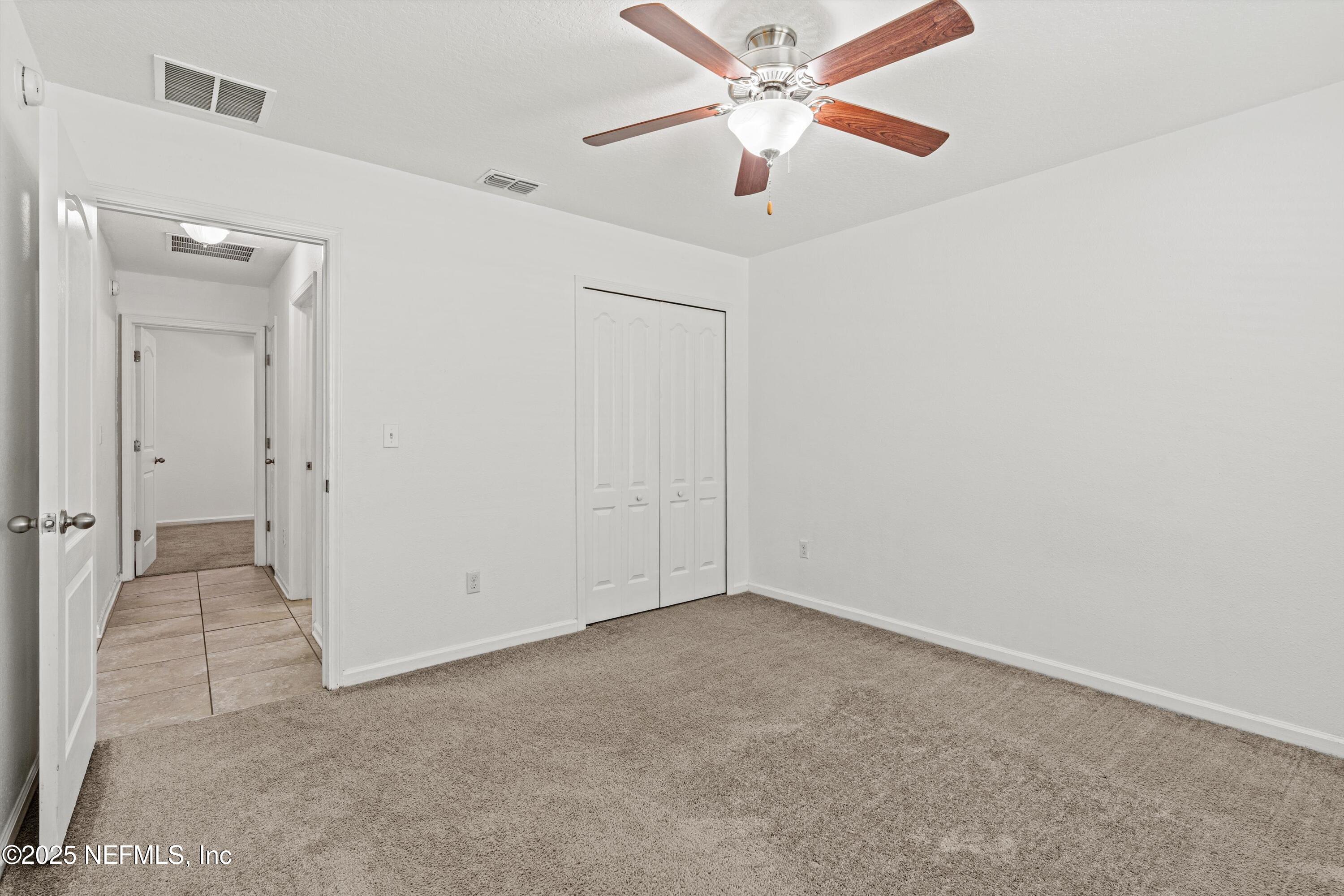 12264 Sacha Road Jacksonville, FL 32226 - Photo 20 of 32 an empty room with closet and a chandelier fan