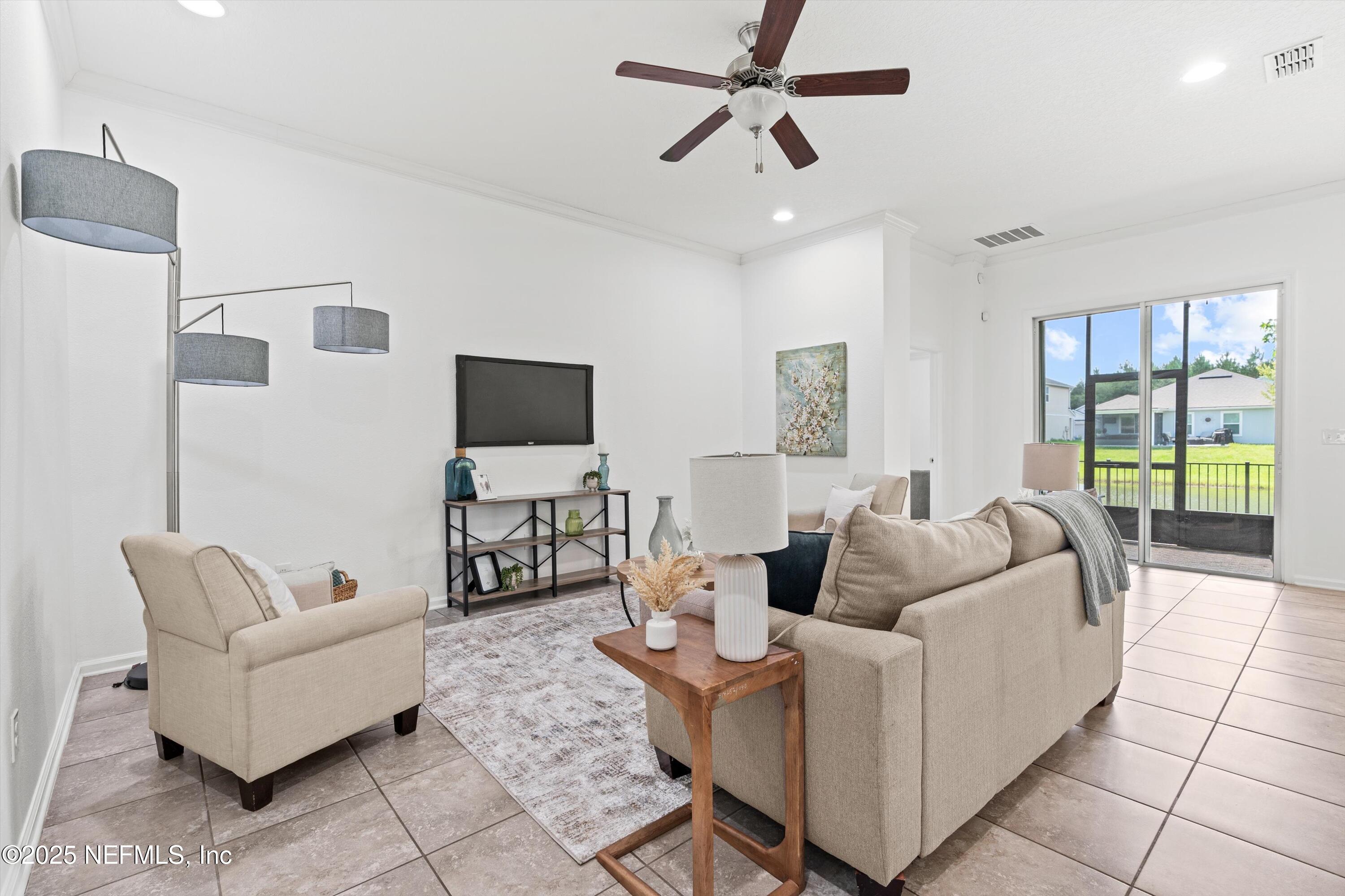12264 Sacha Road Jacksonville, FL 32226 - Photo 2 of 32 a living room with furniture and a flat screen tv