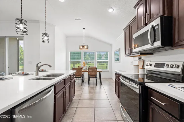a kitchen with stainless steel appliances granite countertop a sink and a stove