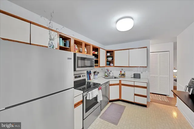 a kitchen with stainless steel appliances a sink and a refrigerator