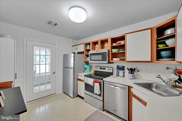 a kitchen that has a lot of cabinets in it and wooden floors