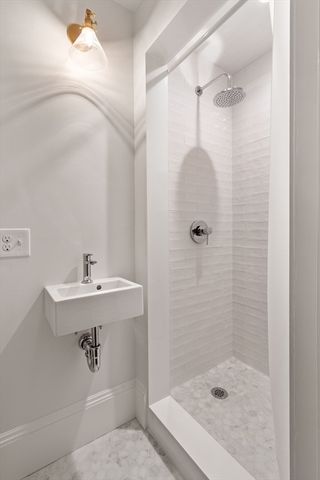 a bathroom with a sink a shower and mirror