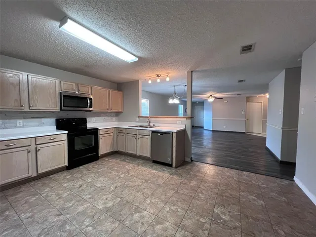a large kitchen with a stove top oven and sink