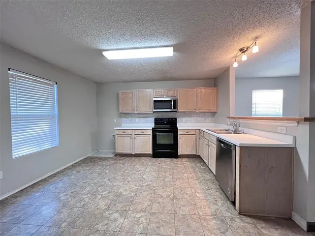 a kitchen with a stove sink and cabinets