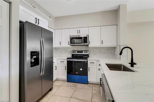 a kitchen with a refrigerator and a stove top oven
