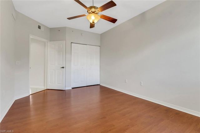 an empty room with a window and a ceiling fan