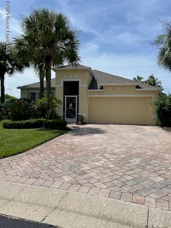 a front view of a house with a yard and trees
