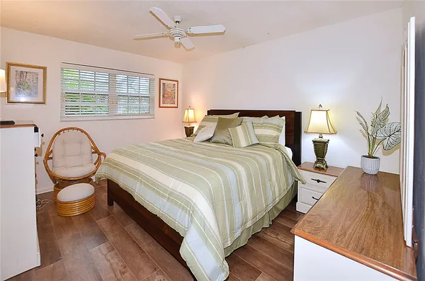 a bedroom with bed and wooden floor