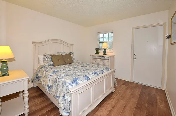 a bedroom with a bed and wooden floor