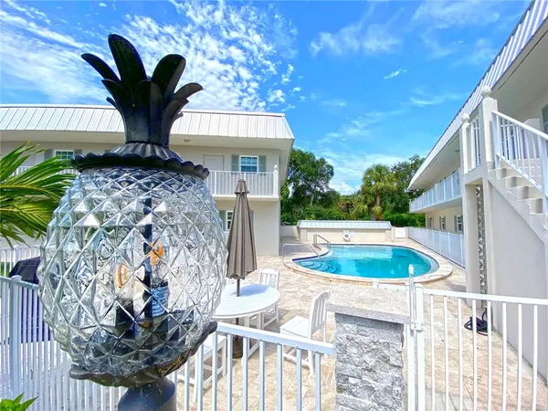 a view of a house with a swimming pool and sitting area
