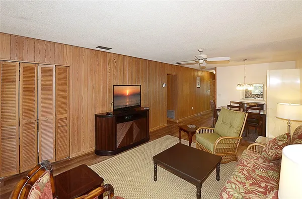 a living room with furniture a flat screen tv and kitchen view