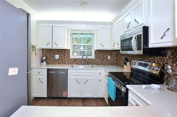 a kitchen with stainless steel appliances granite countertop a sink stove and microwave