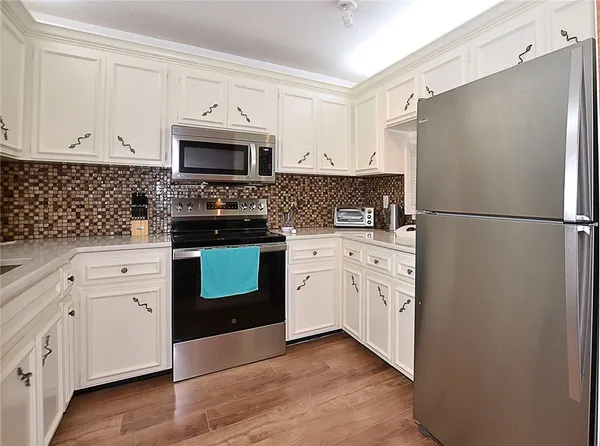 a kitchen with white cabinets and stainless steel appliances