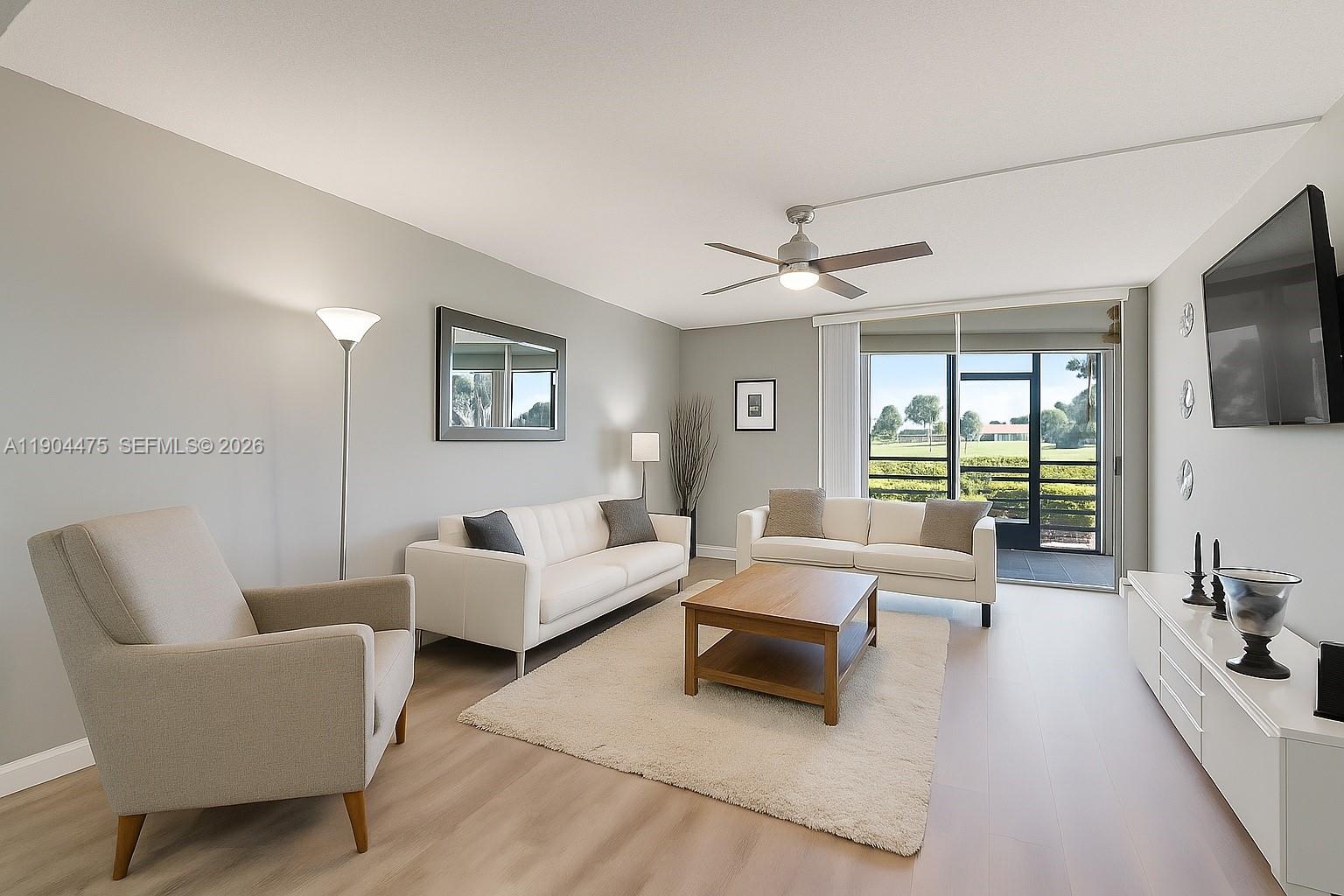 23249 Barwood Lane North, Unit 102 Boca Raton, FL 33428 - Photo 1 of 45 a living room with furniture and a flat screen tv