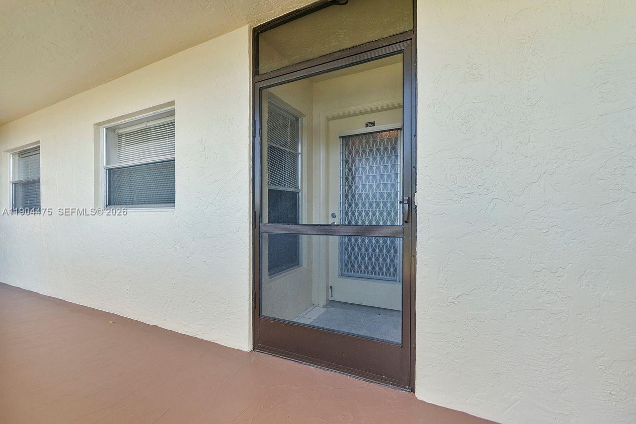 23249 Barwood Lane North, Unit 102 Boca Raton, FL 33428 - Photo 13 of 45 a view of a hallway with wooden floor and entryway