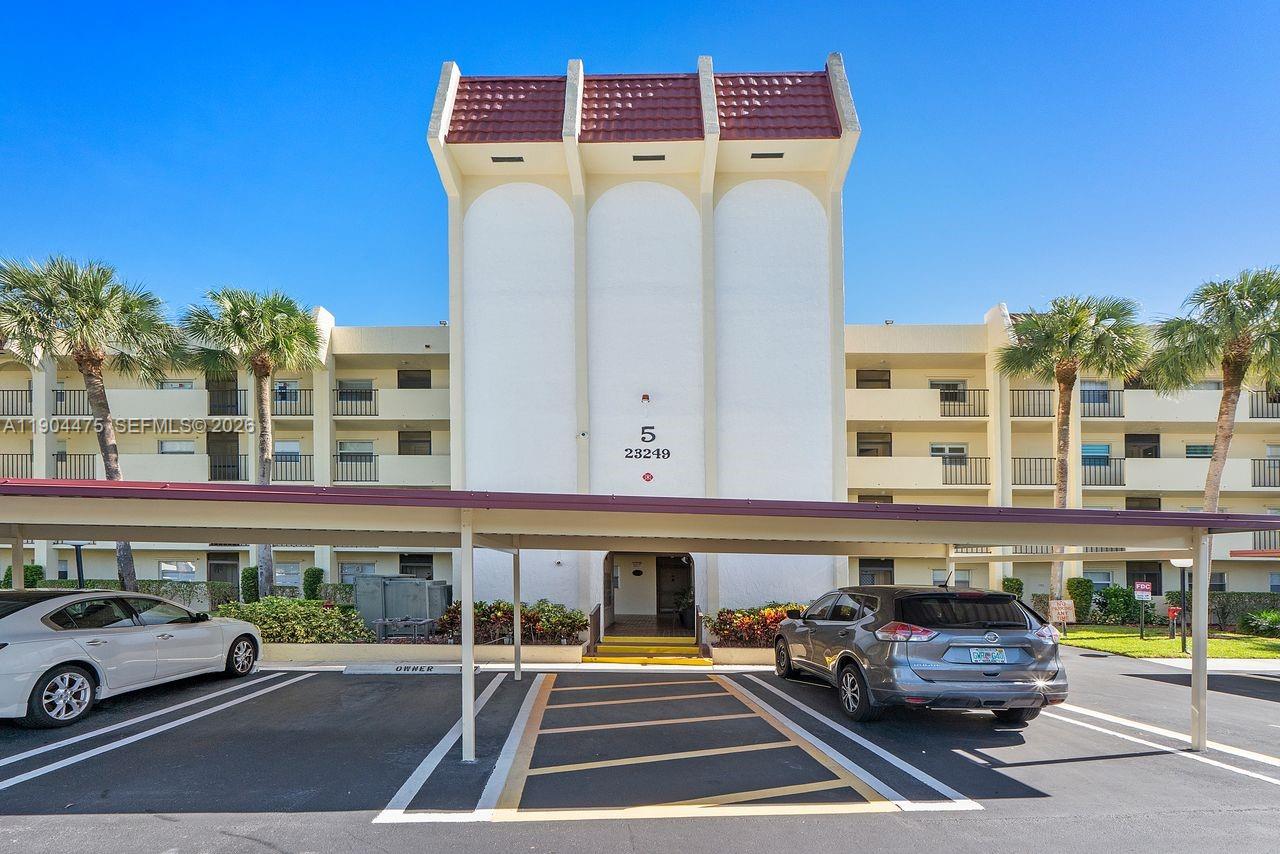 23249 Barwood Lane North, Unit 102 Boca Raton, FL 33428 - Photo 14 of 45 a car parked in front of a building