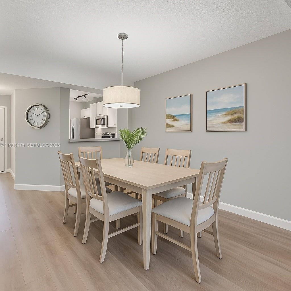 23249 Barwood Lane North, Unit 102 Boca Raton, FL 33428 - Photo 2 of 45 a view of a dining room with furniture wooden floor and a chandelier