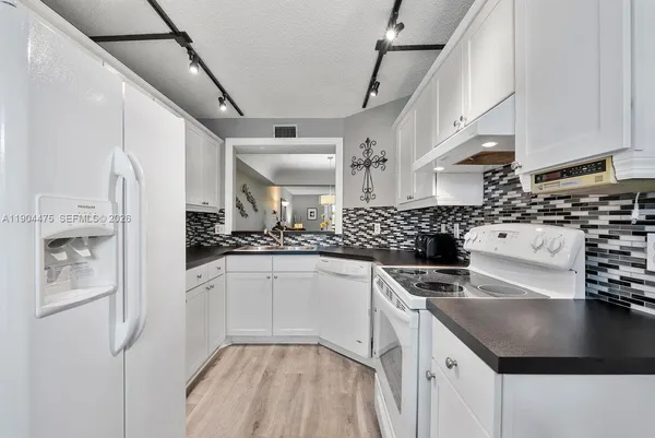 a kitchen with stainless steel appliances granite countertop a sink a stove and a refrigerator