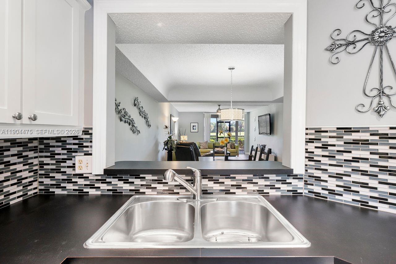 23249 Barwood Lane North, Unit 102 Boca Raton, FL 33428 - Photo 24 of 45 a kitchen with a sink and a stove top oven