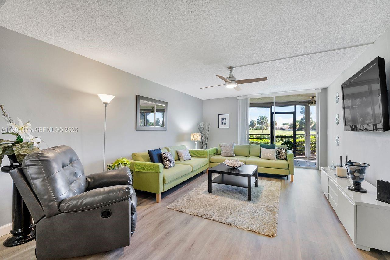 23249 Barwood Lane North, Unit 102 Boca Raton, FL 33428 - Photo 25 of 45 a living room with furniture and a flat screen tv