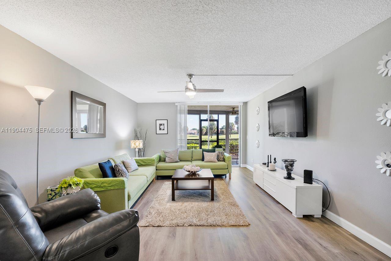 23249 Barwood Lane North, Unit 102 Boca Raton, FL 33428 - Photo 26 of 45 a living room with furniture and a flat screen tv