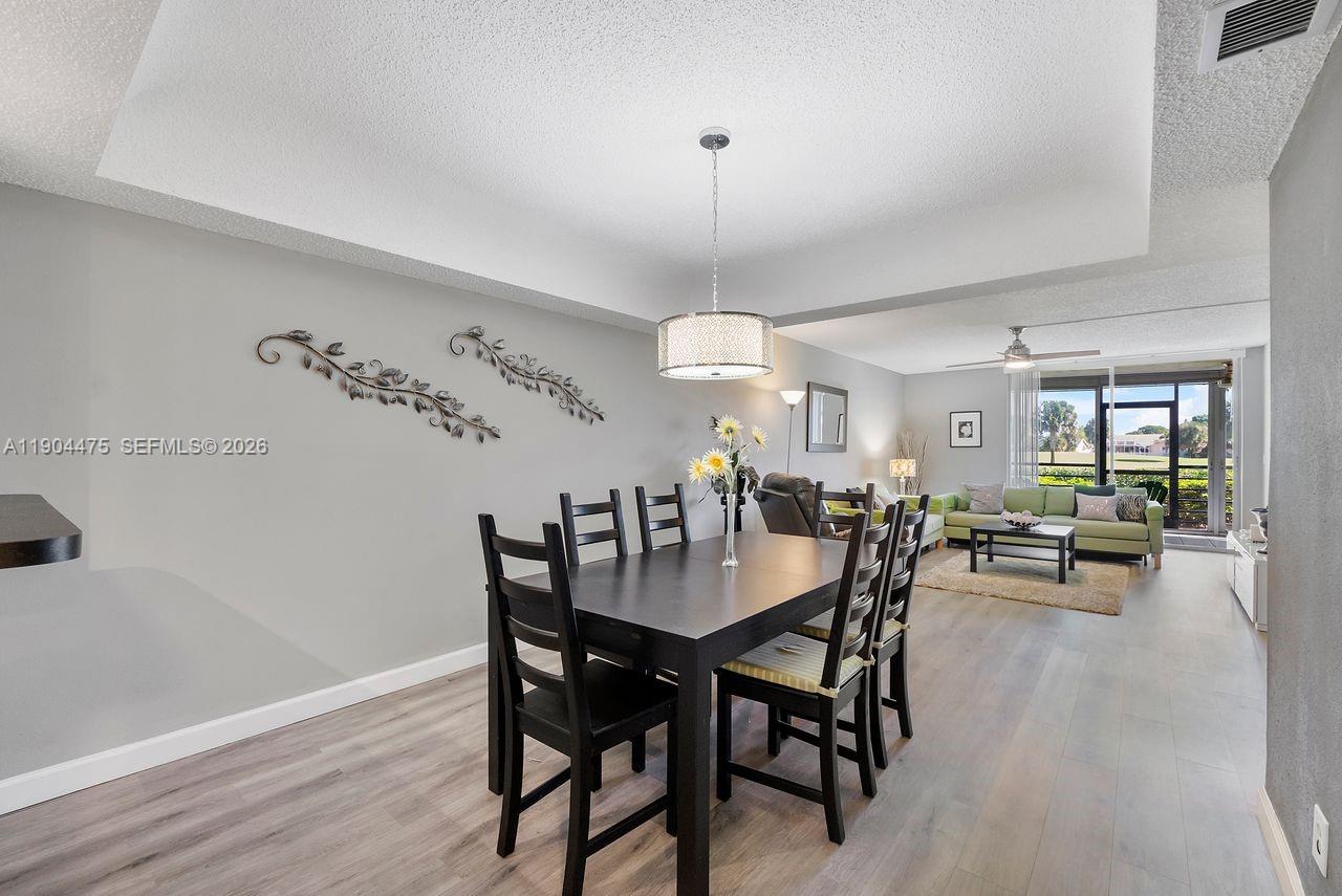 23249 Barwood Lane North, Unit 102 Boca Raton, FL 33428 - Photo 27 of 45 a view of a dining room with furniture and wooden floor