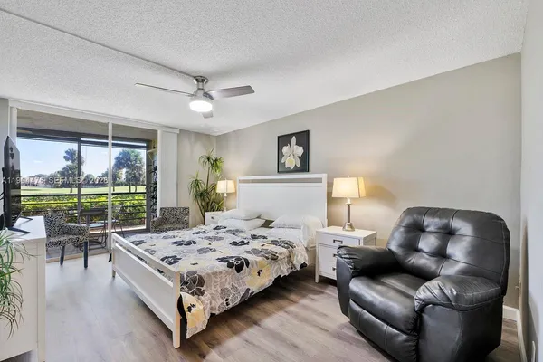 a bedroom with a bed couch and a large window
