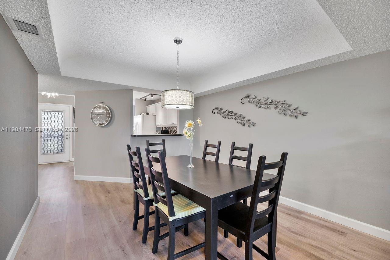 23249 Barwood Lane North, Unit 102 Boca Raton, FL 33428 - Photo 30 of 45 a view of a dining room with furniture and wooden floor