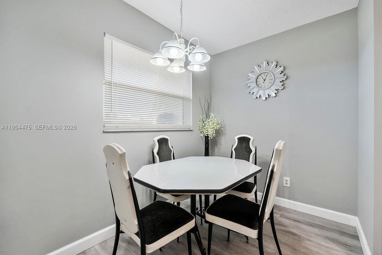 23249 Barwood Lane North, Unit 102 Boca Raton, FL 33428 - Photo 32 of 45 a view of a dining room with furniture and chandelier