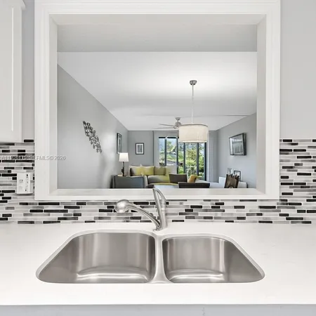 a view with kitchen island a sink appliances and a counter top