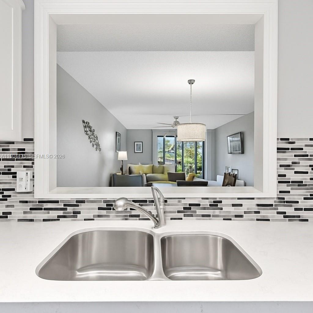 23249 Barwood Lane North, Unit 102 Boca Raton, FL 33428 - Photo 5 of 45 a view with kitchen island a sink appliances and a counter top