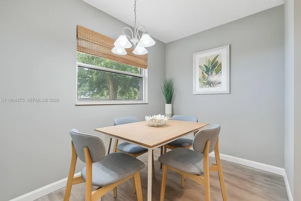 a view of a dining room with furniture a chandelier and wooden floor